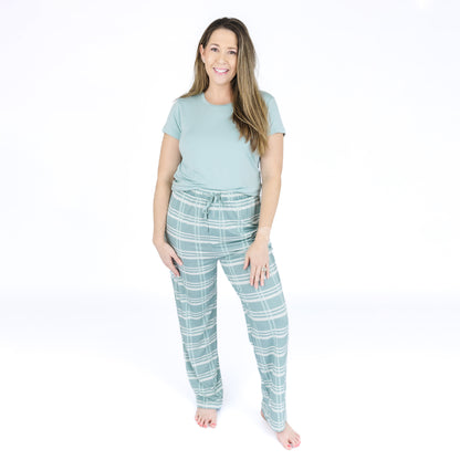Woman wearing a light blue t-shirt and plaid pants on a white background
