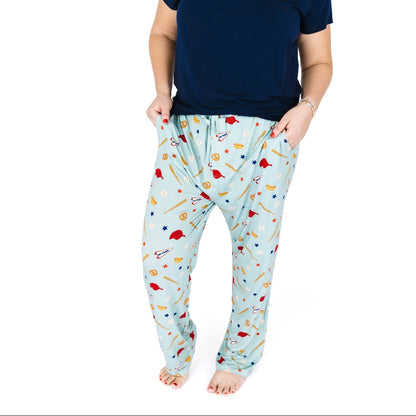Person wearing light blue pajama pants with colorful patterns on a white background