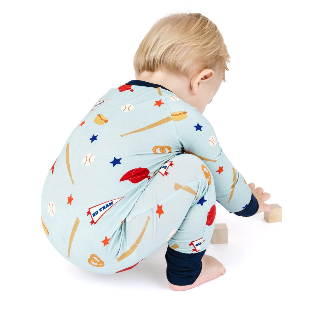 Baby wearing a light blue onesie with colorful patterns on a white background