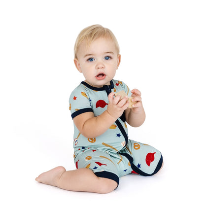 Baby wearing a colorful onesie with airplane pattern on a white background