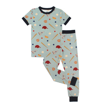 Children's pajama set with sports-themed pattern on a light blue background
