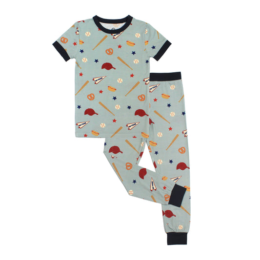 Children's pajama set with sports-themed pattern on a light blue background