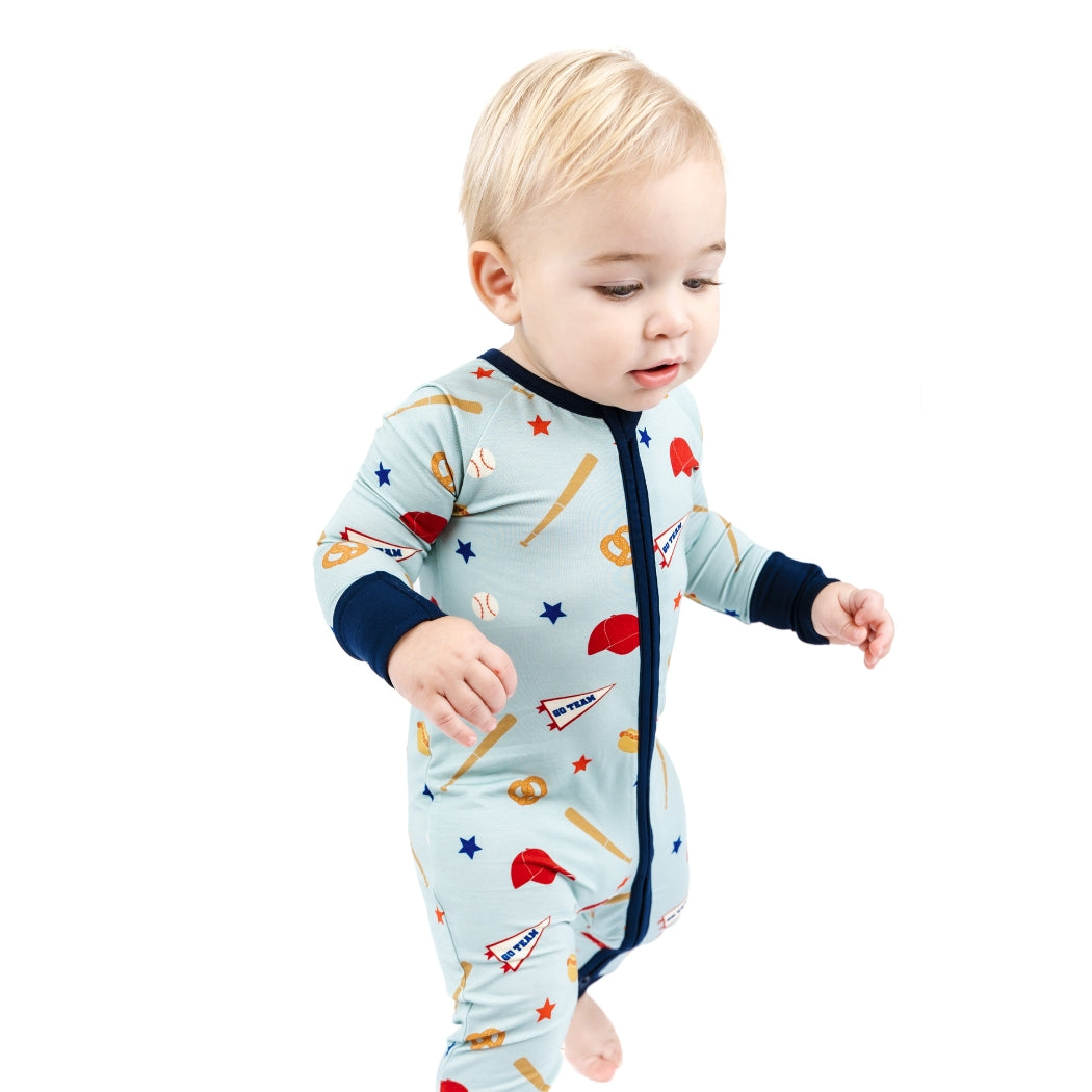 Baby wearing a colorful onesie with sports-themed design on a white background