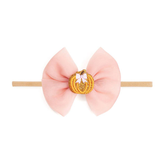 baby headband with a pink bow and an orange pumpkin in the center