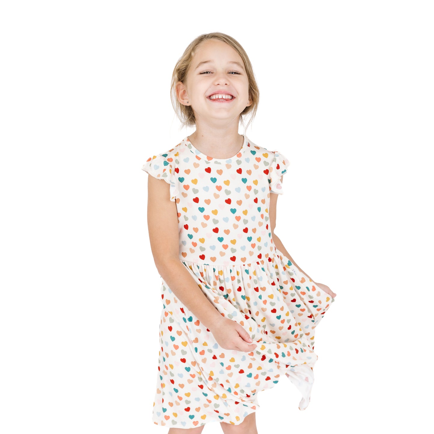 Smiling child in Rainbow Hearts bamboo twirl dress.