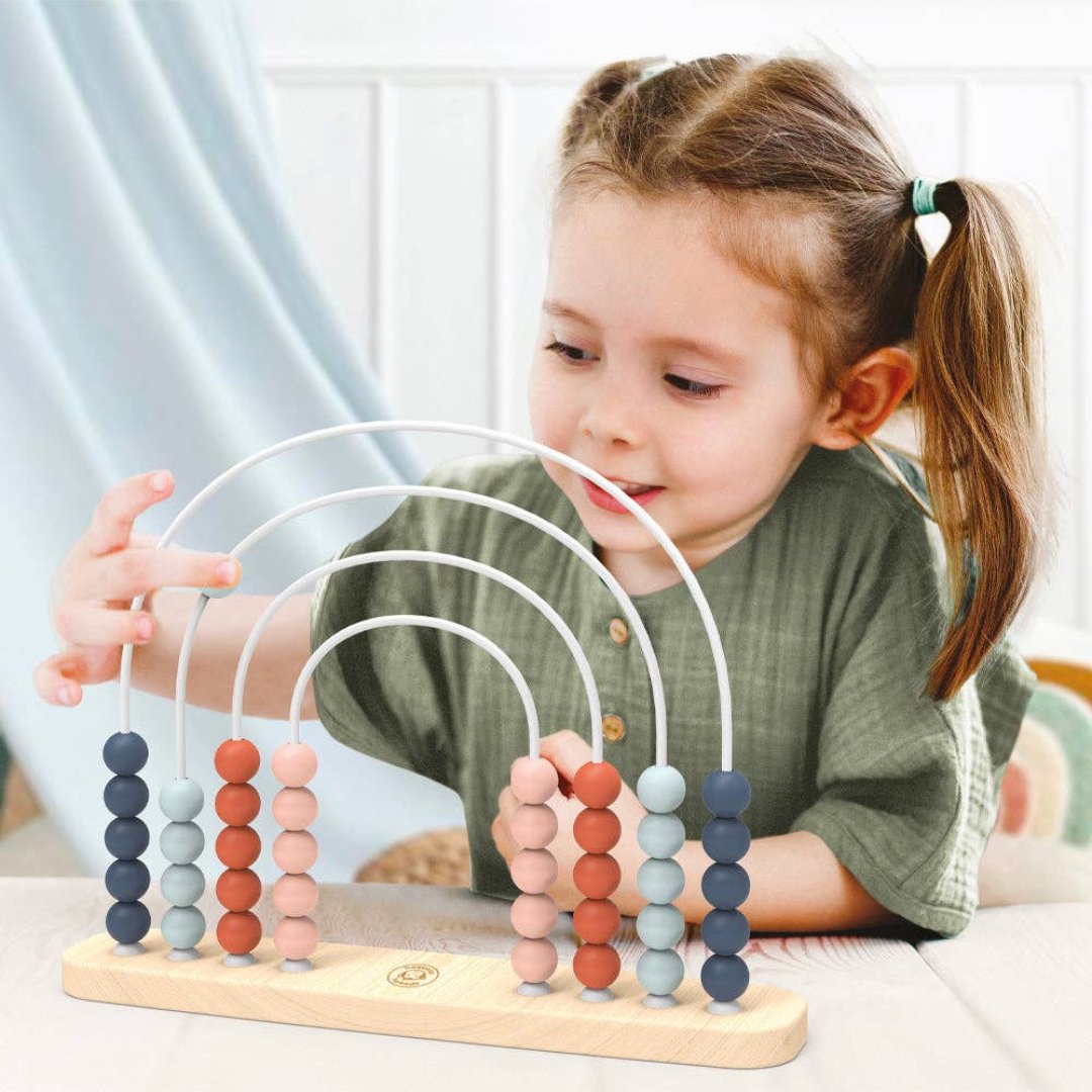 little girl playing with rainbow abacus toy with 4 different colored beads