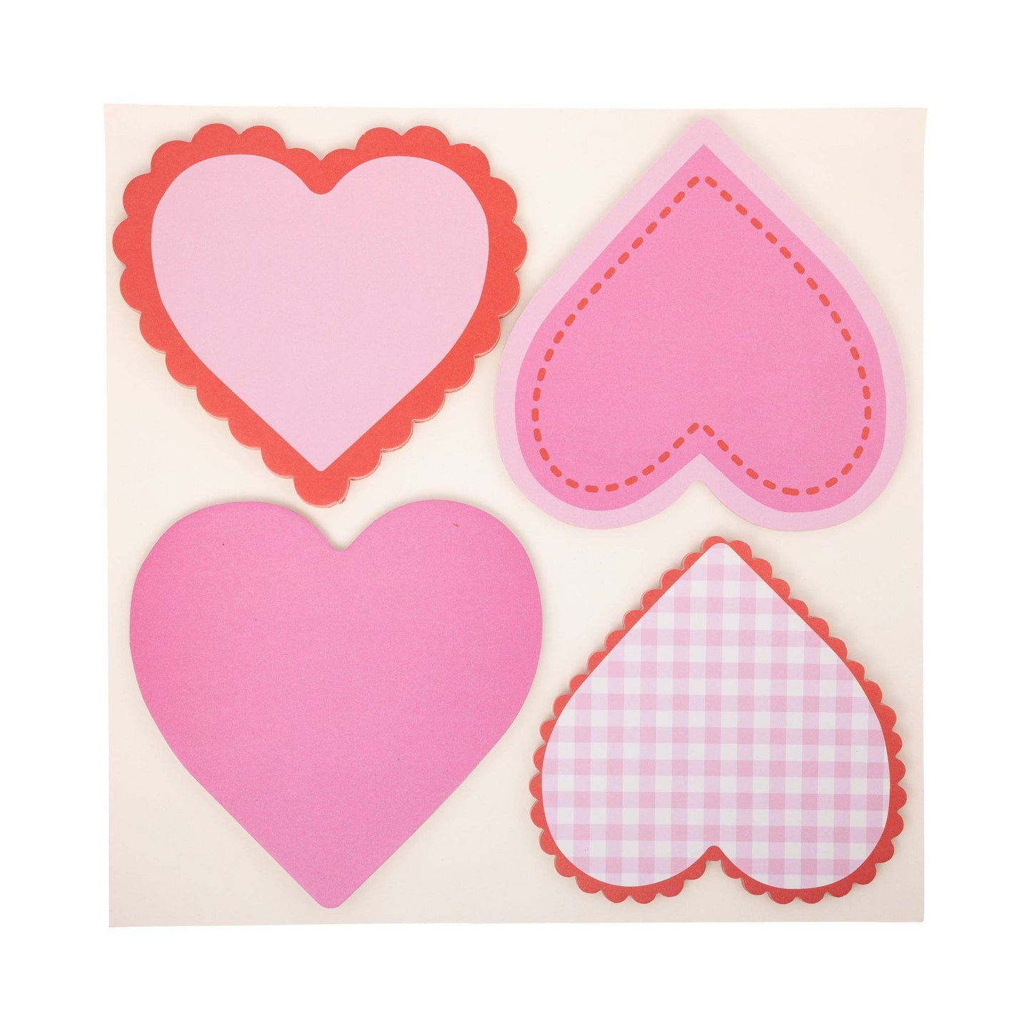 Four pink heart-shaped stickers with different decorative edges on a beige background