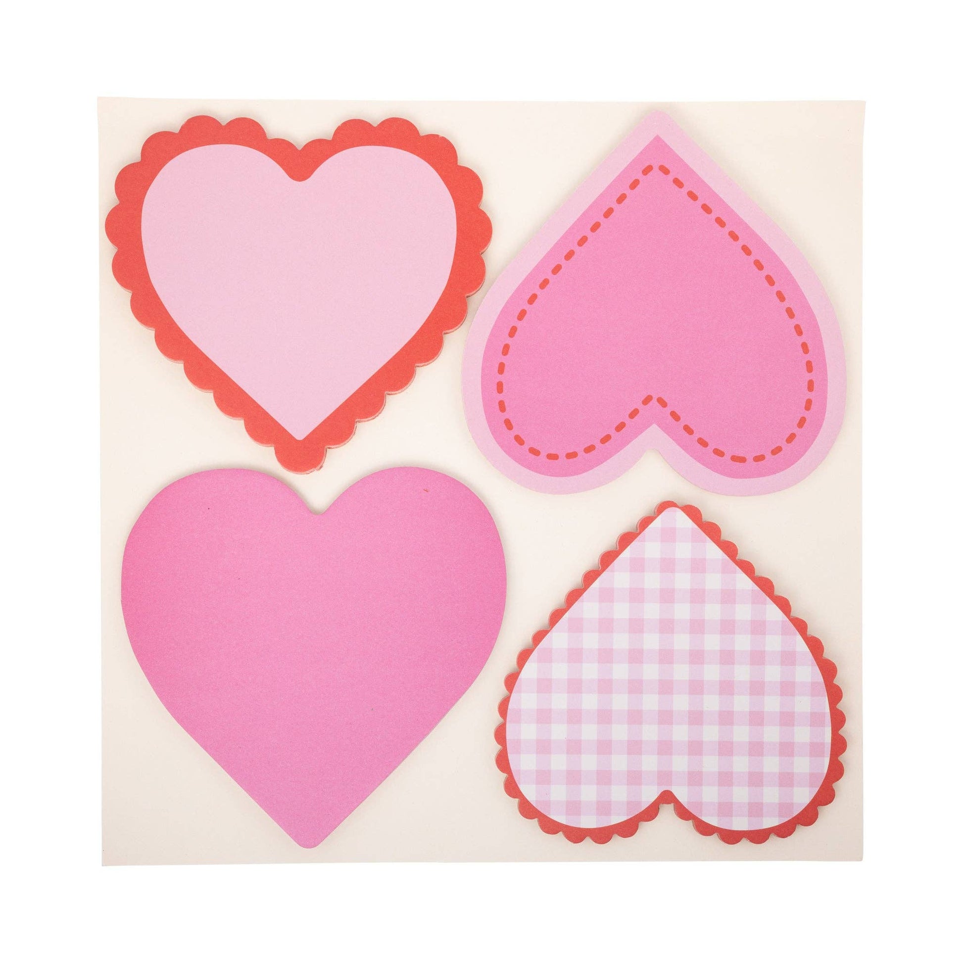 Four pink heart-shaped stickers with different decorative edges on a beige background
