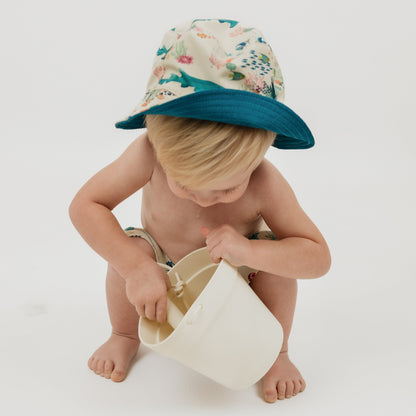 Baby boy wearing our Emerson and Friends Coral Reef Reversible Bucket Hat, featuring a vibrant underwater-inspired design with sharks, sea turtles, and coral, offering sun protection and a stylish, adjustable fit for kids and toddlers.