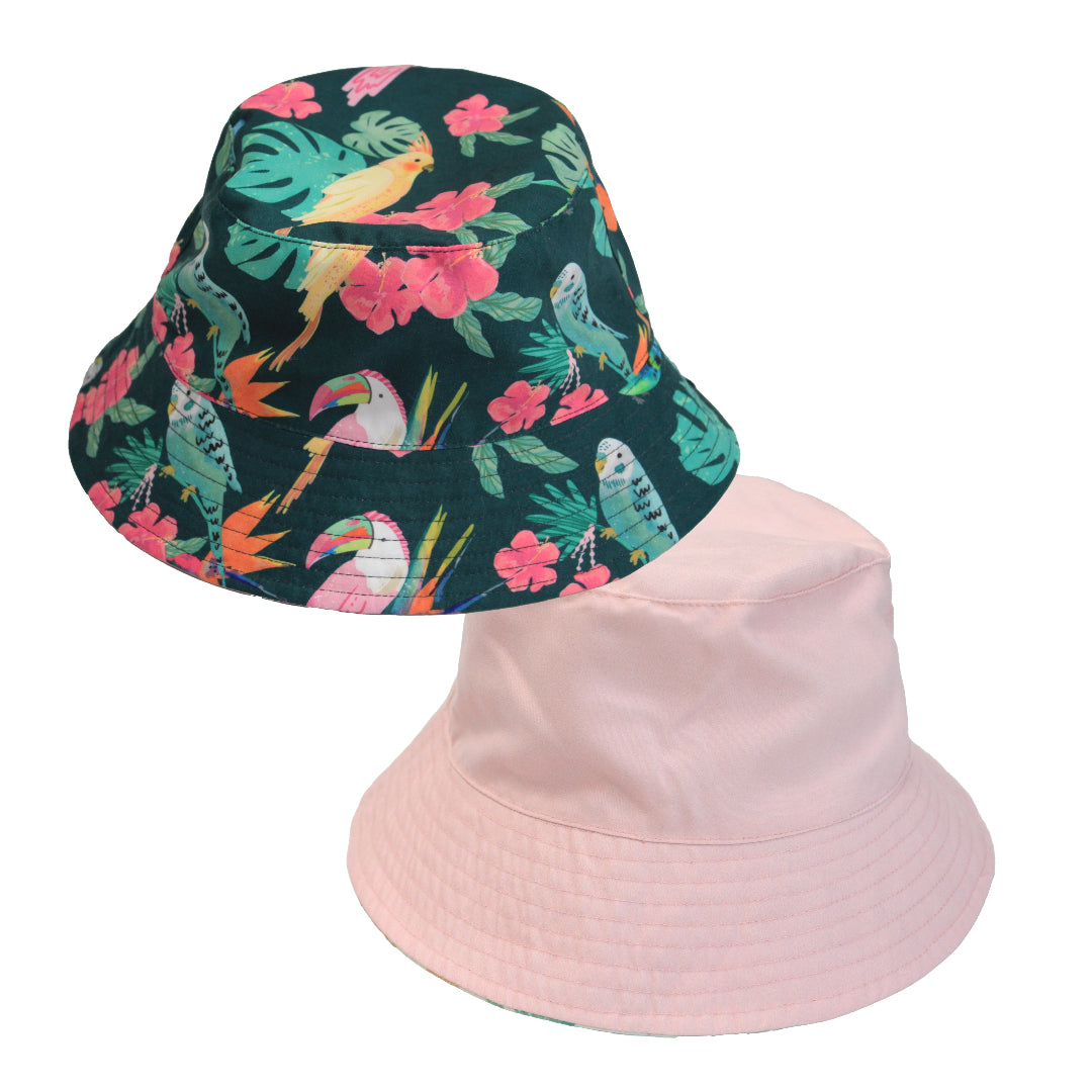 Product shot showing the reversible sides of the Isla Botánica hat: a lush tropical bird print and a coordinating solid Bubblegum Pink interior.