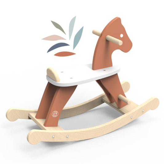 Wooden rocking horse toy with a white seat, natural wood base, and rust-orange sides shaped like a horse’s head, shown on a white background with a small decorative leaf pattern above it.