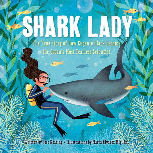 a book with a lady scuba diving with a friendly shark in front of her and lots of fish