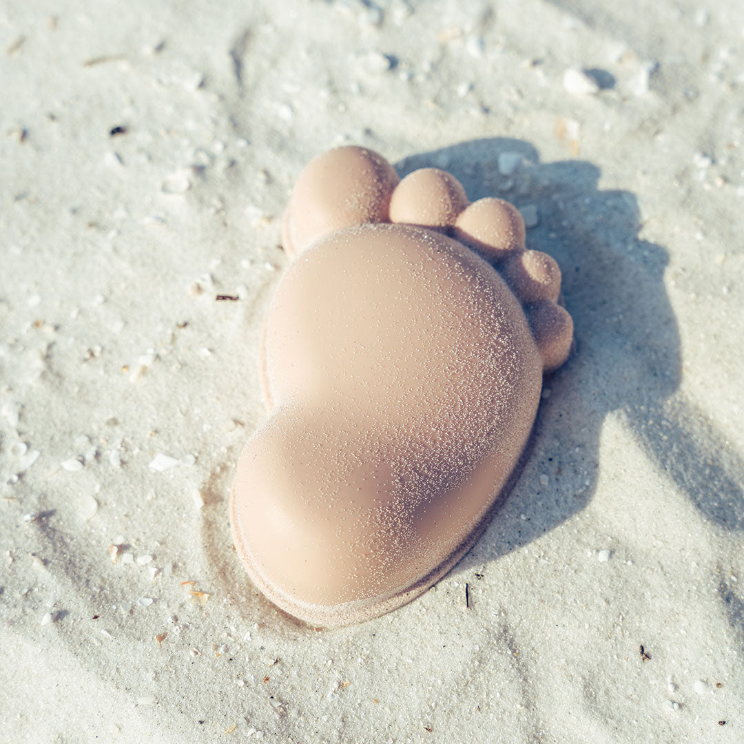 the purple foot lays in the sand