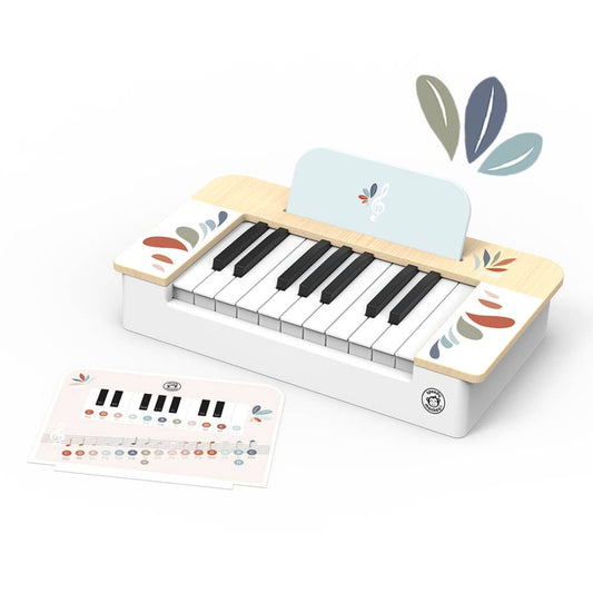 Small wooden toy piano with black and white keys, light wood accents, and colorful leaf designs. A matching music guide sheet with notes and key labels is placed beside it.