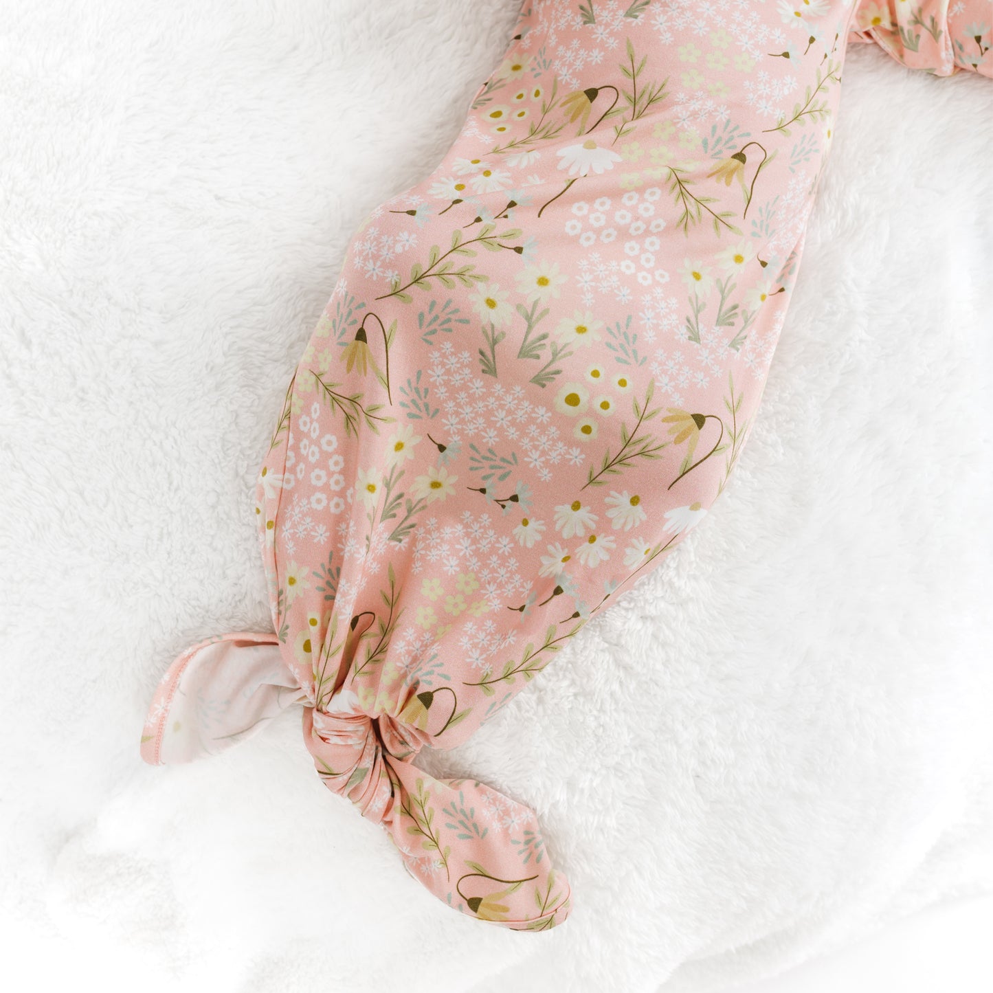 Floral-patterned baby wrap on a white surface