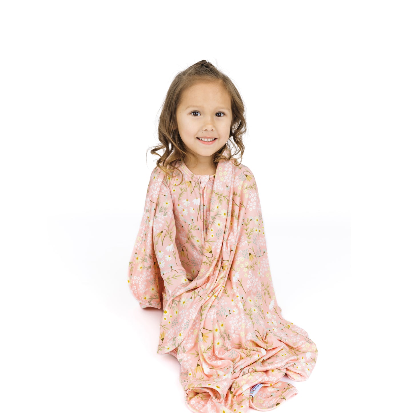 Young girl wearing a pink floral dress on a white background