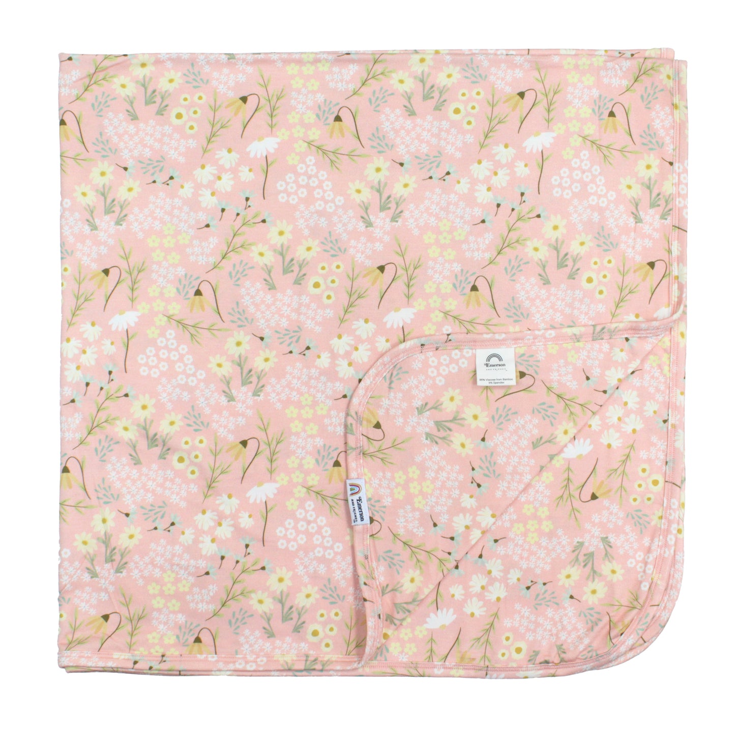 Floral-patterned blanket with a visible brand label on a pink background