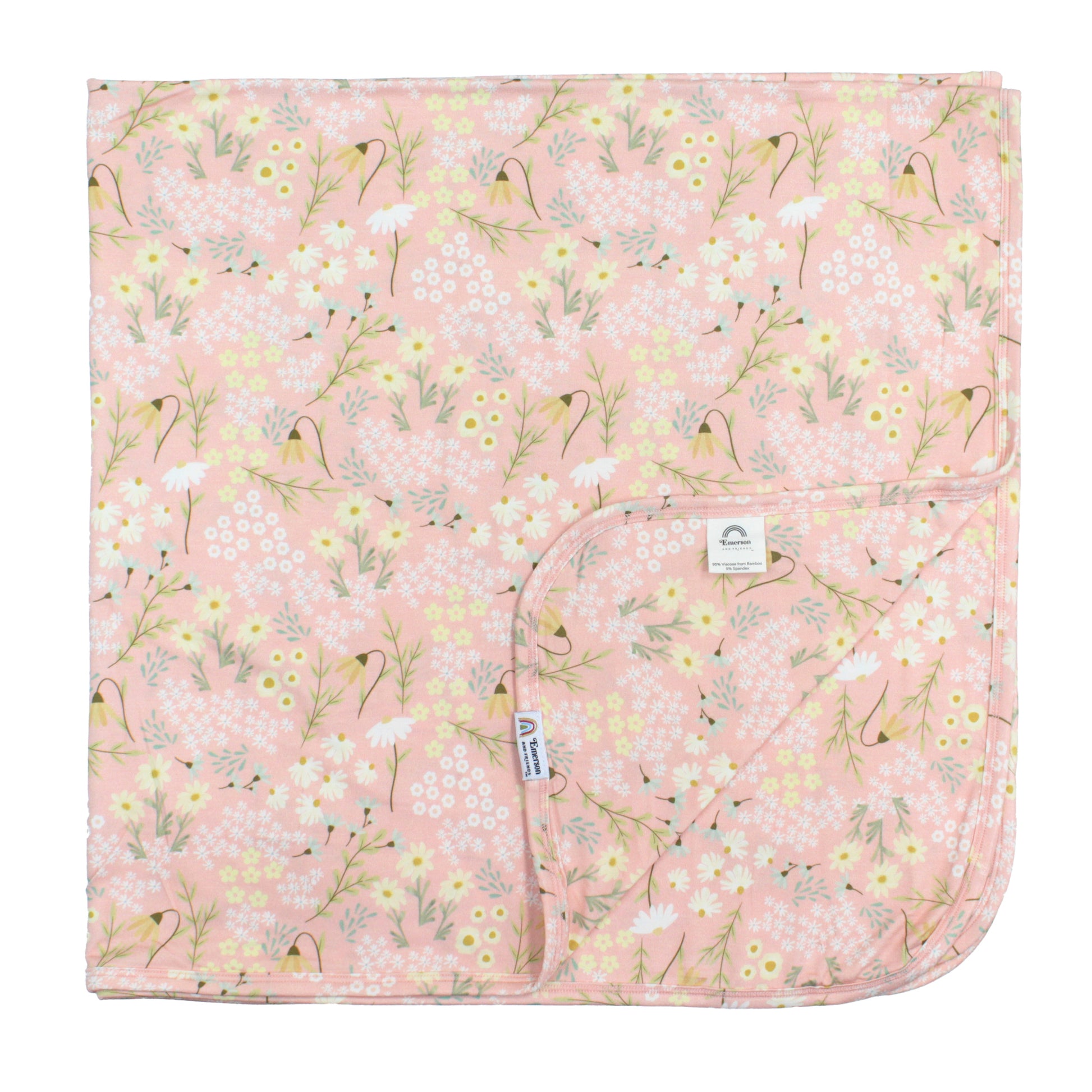 Floral-patterned blanket with a visible brand label on a pink background