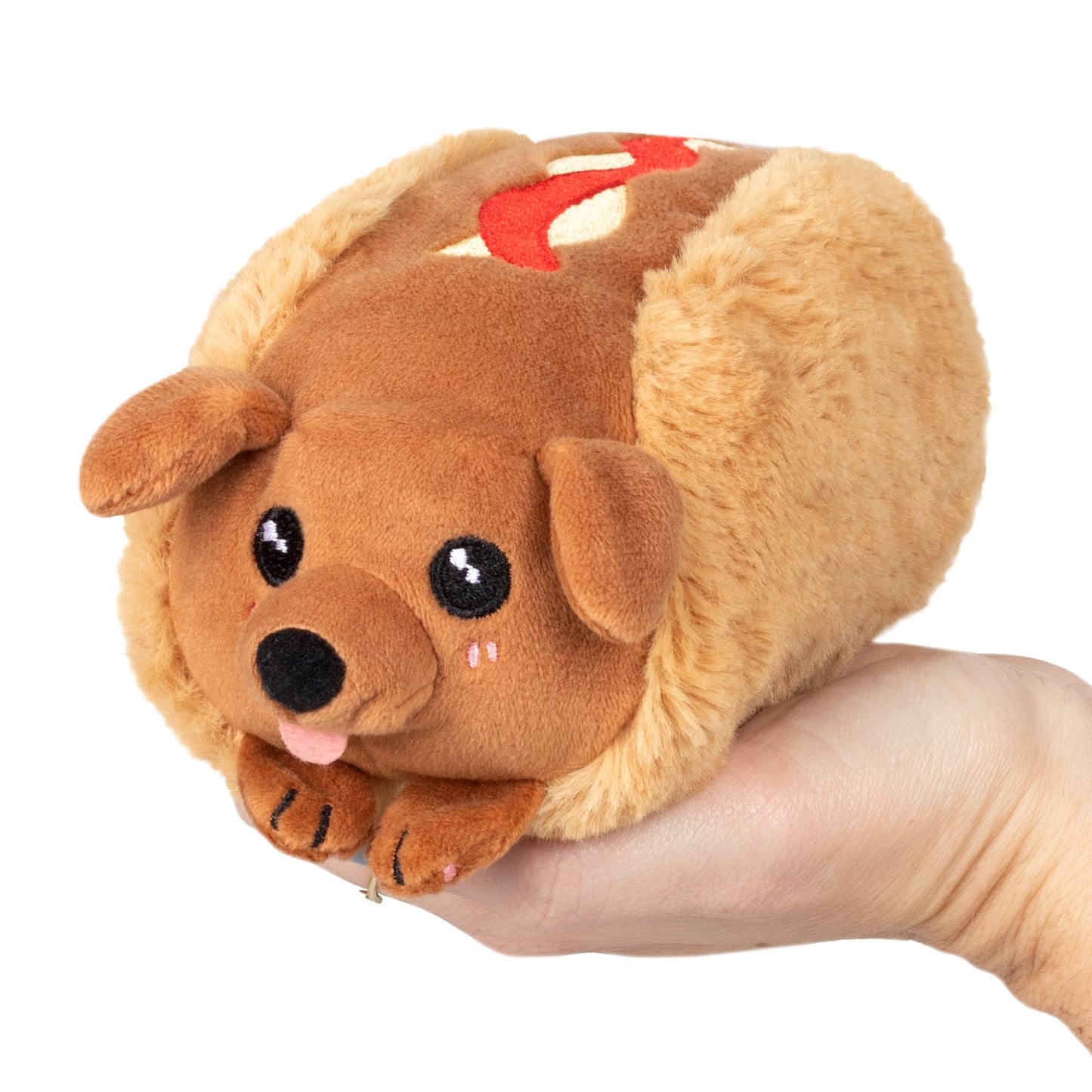 Plush dog toy held in a hand against a white background