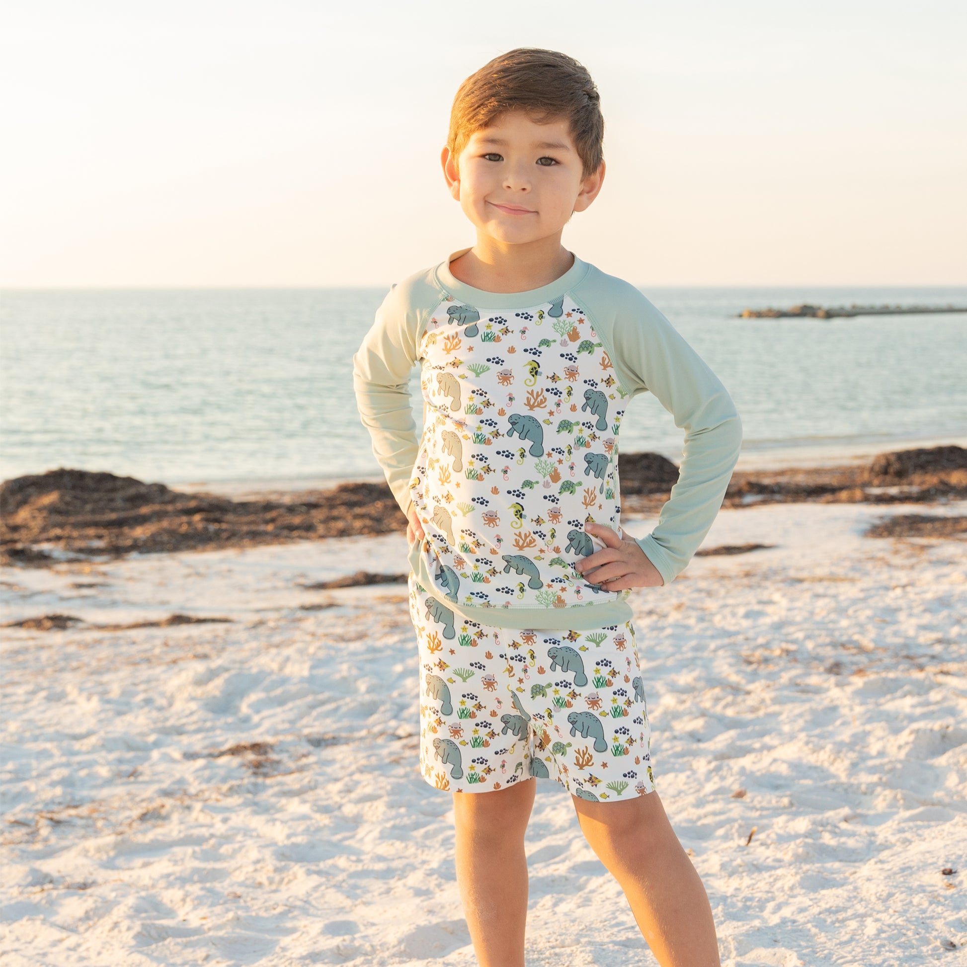 Child wearing a patterned outfit on a beach