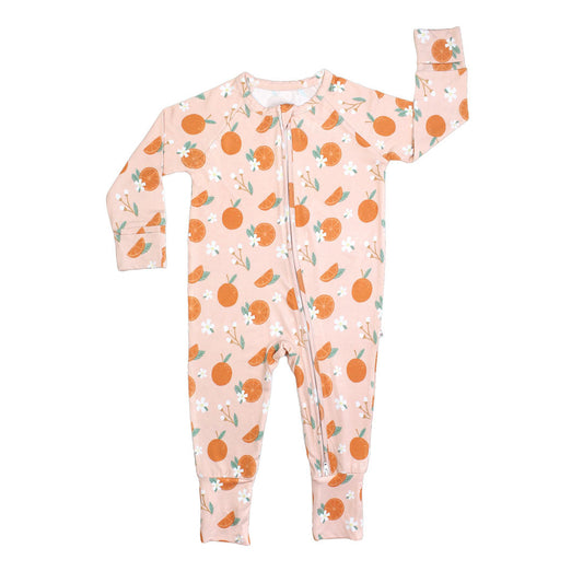 the "freshly squeezed" bamboo convertible. the "freshly squeezed" print has an assortment of full and half cut oranges scattered around. there is also flower heads and flower stems that intermingle within the print. this is all space out around a pink background space. 