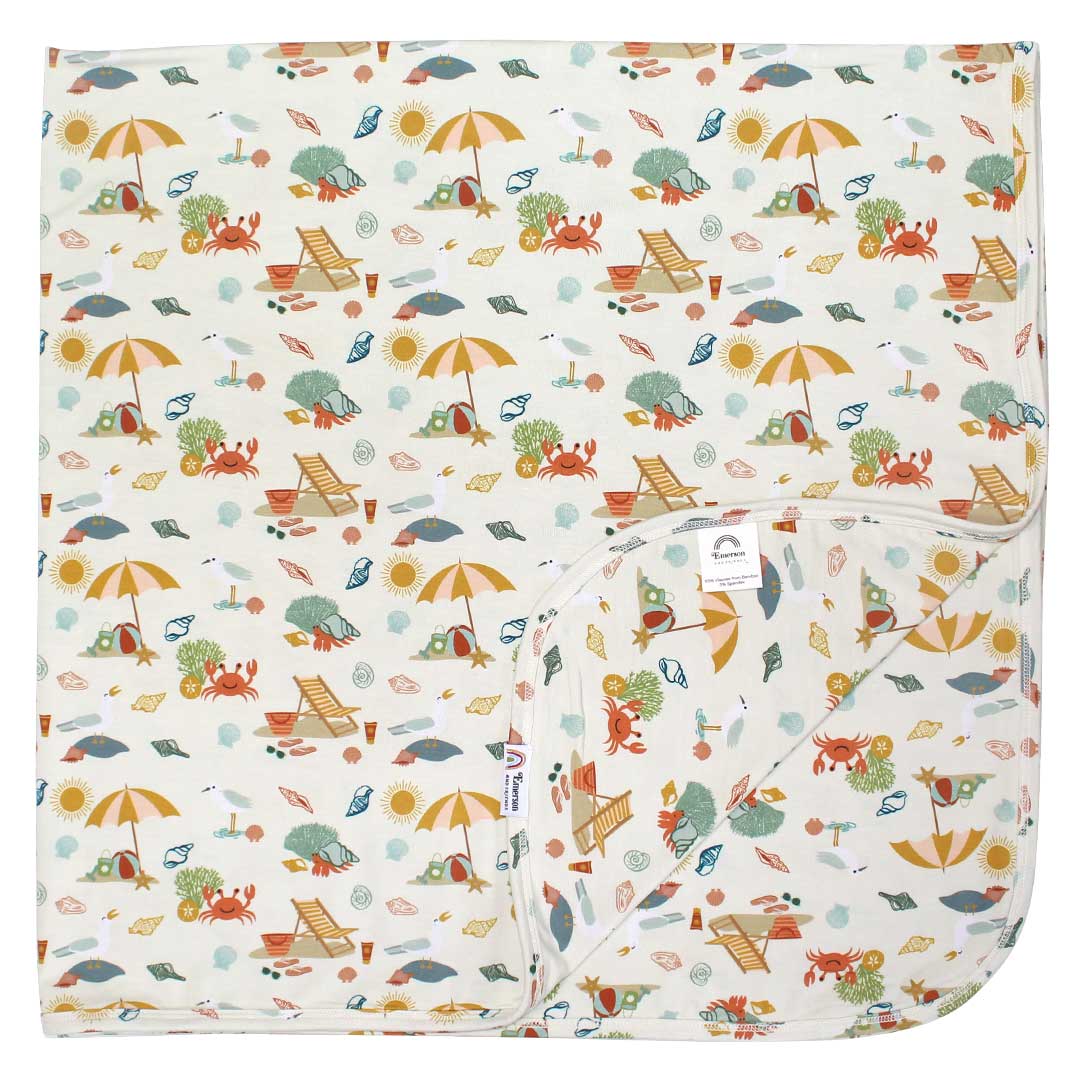 the "beach days" bamboo blanket. the "beach days" print is a scattered print of beach umbrellas, beach balls, sand buckets and shovels, coral, shells, beach chairs, seagulls, flipflops, and sunglass mixed in a orderly and creative way. 