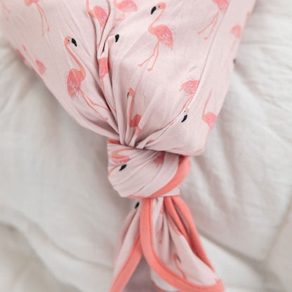 a close up of the "fancy flamingos" gown with a knot at the bottom of it. the "fancy flamingos" print is a pattern of multiple pink flamingoes scattered around the print. 