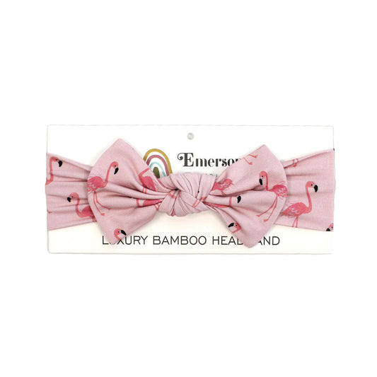 the "fancy flamingos" headband. the "fancy flamingos" print is a pattern of multiple pink flamingoes scattered around the print. 