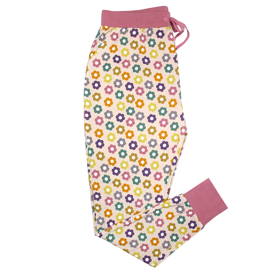 the "feeling groovy" women's jogger pants. the "feeling groovy" print is a flowered print in multiple colors. these flowers are retro and groovy. the background is light pink. 