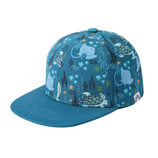 the "ocean friends" snapback hat has the "ocean friends print around the bowl and blue on the lip. the "ocean friends" print is a combination of dolphins, stingrays, fish, starfish, coral, bubbles, and sharks, all spread out on a deep sea blue background.