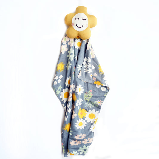 the "blue daisy" lovey, with a yellow flower attached to the top. the "blue daisy" print is an arrangement of tons of different, colorful flowers scattered around a dark blue print. 