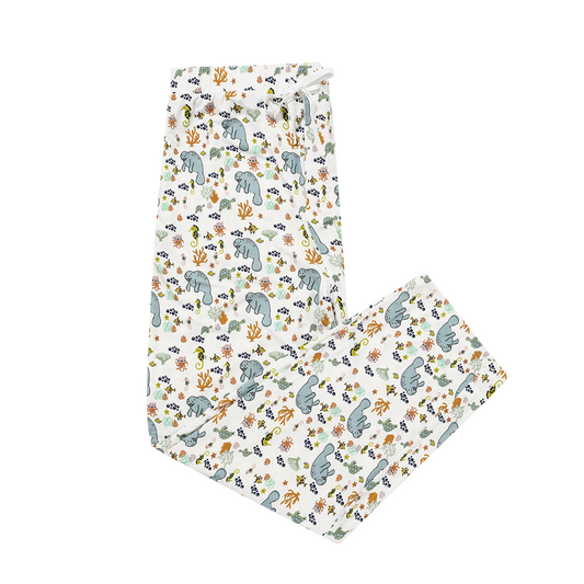 the "manatee" relaxed pants. the print "manatee" unites the florida sea life in a majestic print. there is a variation of florida manatees, yellow and pink sea horses, yellow and pink starfish, bubbles, turtles, and coral patterned across a white background