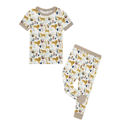 the "jungle friends" matching pajama set. the "jungle friends" print is a mix of jungle animals that include giraffes, lions, cheetahs, sloths, snakes, and forest plants. 