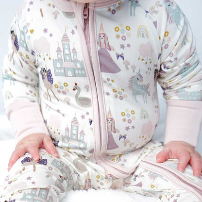 a close up of a baby's tummy in the "once upon a time" convertible. the "once upon a time" print is a mix of pinks, purples, whites, blues, and yellows. you can see fairy princess and regular princess, unicorns, swans, and castles. theres also hearts, stars and sparkles scattered around the print. 