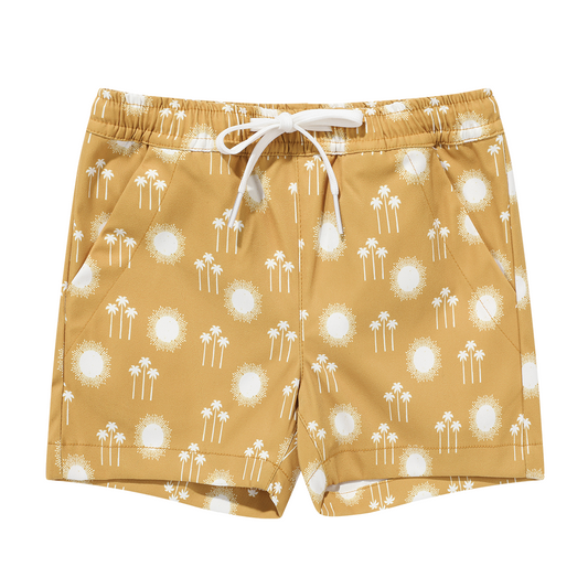the "sunny days" boy swim trunks. the "sunny days" print is a boho styled print of white palm trees and suns scattered among a mustard yellow background. 