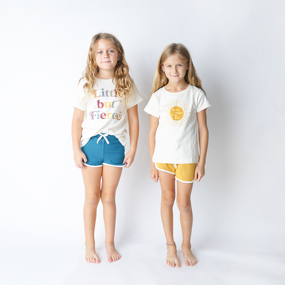 2 girls stand next to one another. both are wearing the terry track shorts. the girl on the left is wearing them in blue, the girl on the right wears them in yellow. 