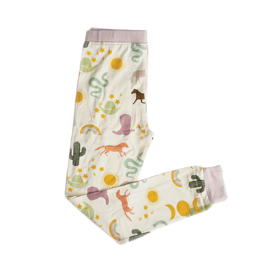 the "wild and free" women's jogger pants. the "wild and free" print is a mix of colorful horses, snakes, cowboy hats, cacti, suns, stars, moons, and rainbows, all on a white background. this is a boho cowboy design. 