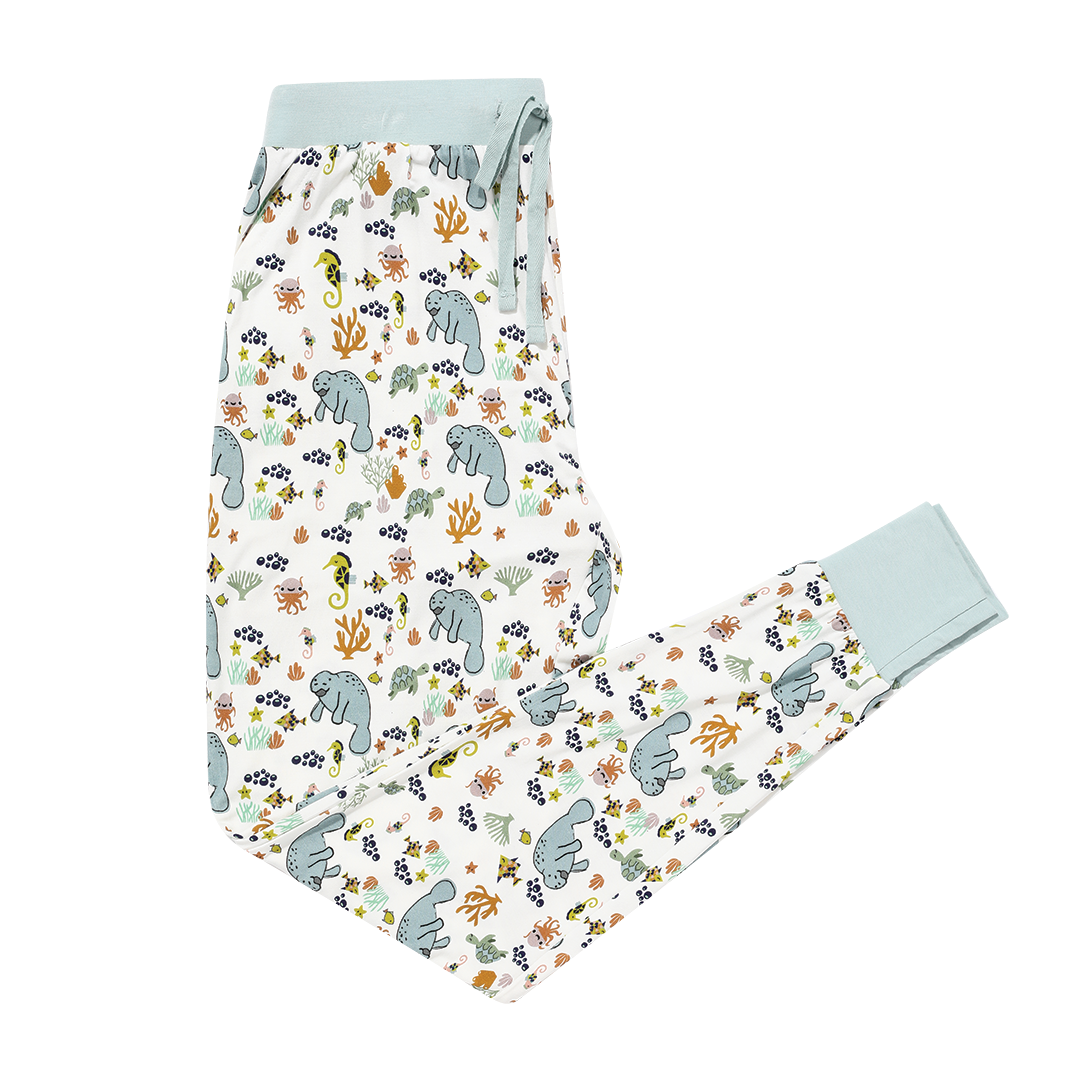 the "manatee" women's jogger. the print "manatee" unites the florida sea life in a majestic print. there is a variation of florida manatees, yellow and pink sea horses, yellow and pink starfish, bubbles, turtles, and coral patterned across a white background