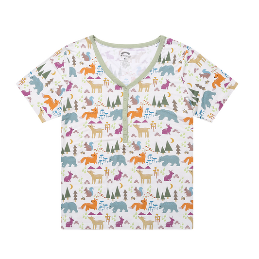 the "forest friends" women's top. the "forest friends" print has a mix of red foxes, brown deer, blue bears, purple bunnies, trees, grass, mushrooms, acorns, moons, and other colored dots scattered over a white background. 