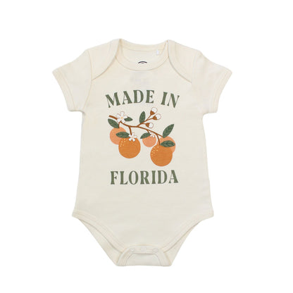 this cotton onesie has the phrase "made in Florida" in green print on the onesie. there is also a branch of oranges on it too. 