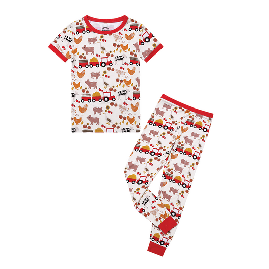 the "farm friends" 2-piece matching pajama set. the "farm friends" print is a collection of chickens, roosters, pigs, bails of hay, tractors, chicks, apples, and pumpkins. it's a white background and flashed of reds, yellows, and oranges, to bring out the farm aesthetic.