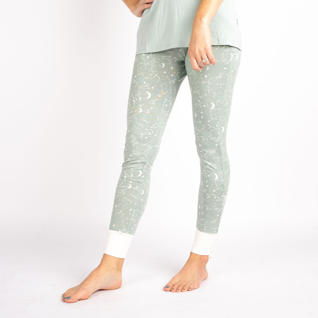 close up of a women wearing the "stargazer" women's joggers. the "stargazer" print is a baby blue background with a mix of moons, constellations, and stars.