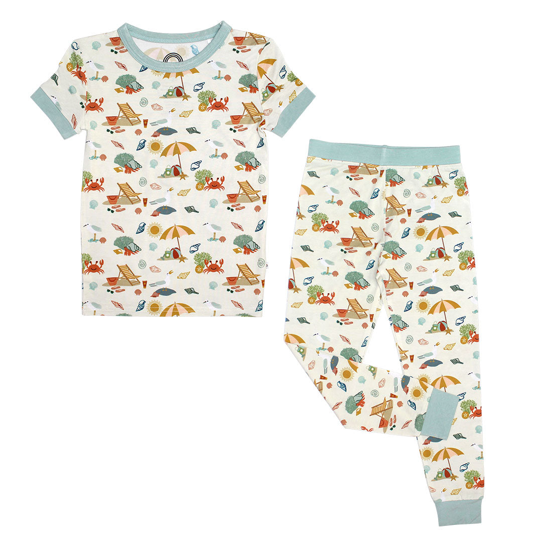 the 2-piece matching pajama set. the "beach days" print is a scattered print of beach umbrellas, beach balls, sand buckets and shovels, coral, shells, beach chairs, seagulls, flipflops, and sunglass mixed in a orderly and creative way. 