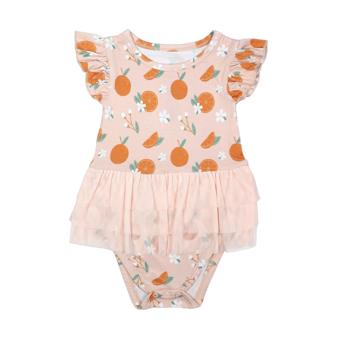 the "freshly squeezed" skirted onesie. This onesie is unique because it's the "freshly squeezed" print as the onesie, and then a pink skirt that wraps around. the "freshly squeezed" print has an assortment of full and half cut oranges scattered around. there is also flower heads and flower stems that intermingle within the print. this is all space out around a pink background space. 