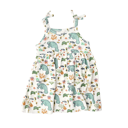 the "manatee" sundress. the print "manatee" unites the florida sea life in a majestic print. there is a variation of florida manatees, yellow and pink sea horses, yellow and pink starfish, bubbles, turtles, and coral patterned across a white background