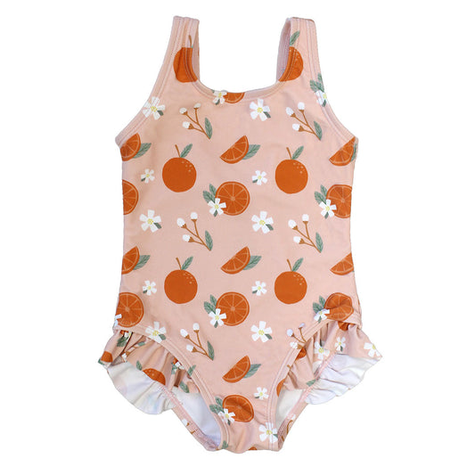 the "freshly squeezed" one piece swimsuit for girls. the "freshly squeezed" print has an assortment of full and half cut oranges scattered around. there is also flower heads and flower stems that intermingle within the print. this is all space out around a pink background space. 