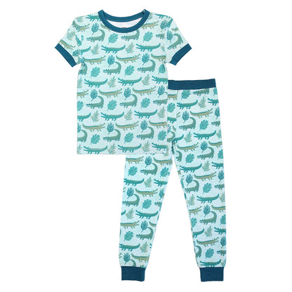 the 2-piece matching pajama set in the "later gator" print. the "later gator" print has a mix of light and dark green alligators, leaves, and white dots scattered on a teal colored background. 