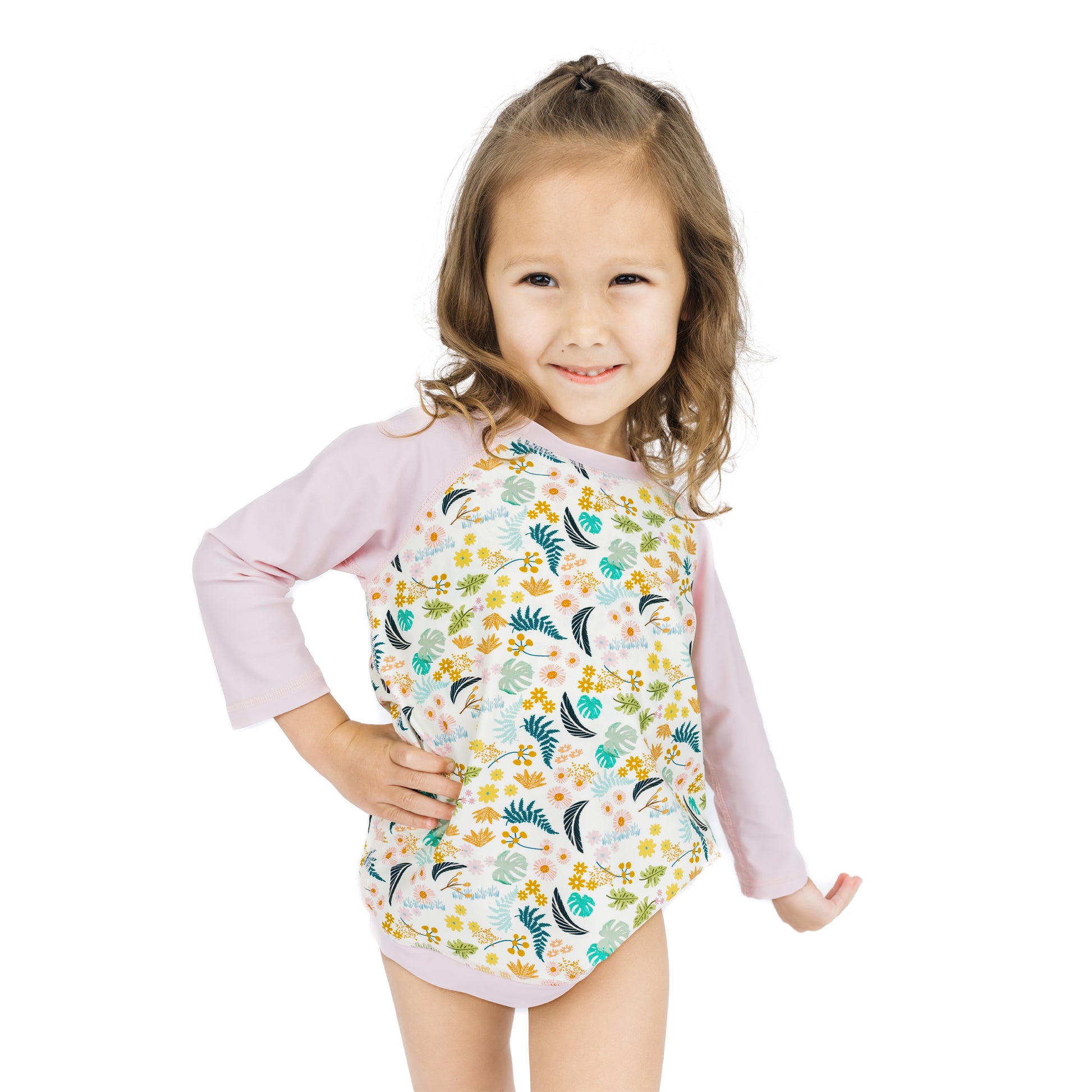 Medium shot of a child in the Tropical Blooms rash guard, highlighting the soft and stretchy UV-protective fabric.