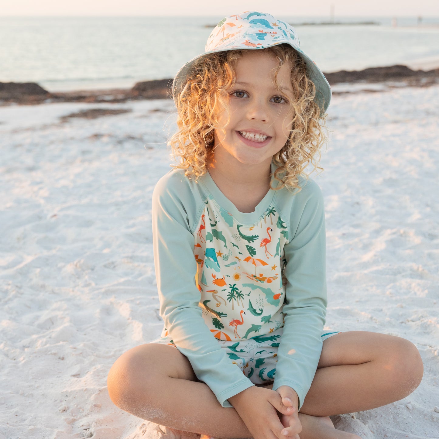 A smiling child wearing the Explore Florida sun hat, showing the wide brim designed to shade the face from the sun.