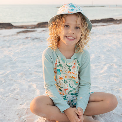 A smiling child wearing the Explore Florida sun hat, showing the wide brim designed to shade the face from the sun.